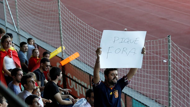 A man displays a banner that reads "Pique Out", referring to Spain's player Gerard Pique, before a training session in Las Rozas, near Madrid, Spain, October 2, 2017. REUTERS/Rafael Marchante - RC1F625D9820