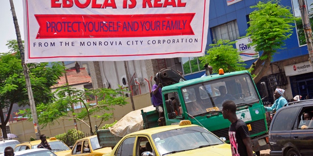 A banner reading: Ebola is real, Protect yourself and your family, warns people of the Ebola virus in Monrovia, Liberia, Saturday Aug. 2, 2014. (AP Photo/Abbas Dulleh)