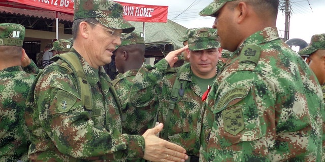 Colombian Army Gen. Ruben Dario Alzate, left, reaching to shake hands with a soldier in Bogota, Colombia.