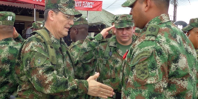 Colombian Army Gen. Ruben Dario Alzate, left, reaching to shake hands with a soldier in Bogota, Colombia.