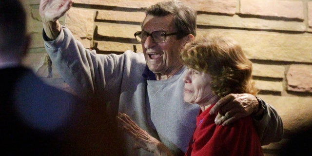 FILE - In this Nov. 9, 2011 file photo, former Penn State Coach Joe Paterno and his wife, Sue Paterno, stand on their porch to thank supporters gathered outside their home in State College, Pa. Sue Paterno says the family’s detailed response to a critical report on the handling of child abuse allegations against former assistant coach Jerry Sandusky is being released to the public. (AP Photo/Gene J. Puskar, File)
