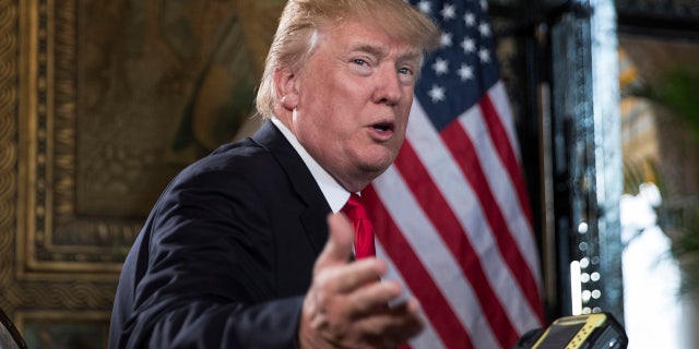 President Donald Trump turns to talk to the gathered media during a Christmas Eve video teleconference with members of the mIlitary at his Mar-a-Lago estate in Palm Beach, Fla., Sunday, Dec. 24, 2017.