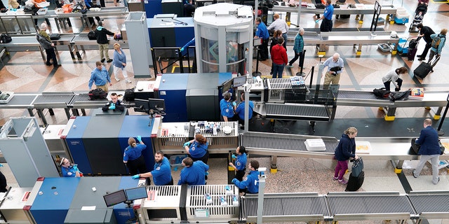 Transportation Security Administration workers at an airport gate.