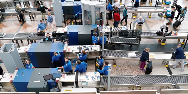 Transportation Security Administration employees at an airport gate.
