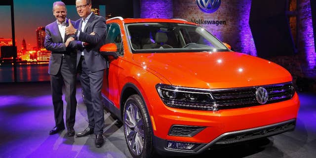 Herbert Diess, left, Member of the Board of Management of Volkswagen AG, Chairman of the Board of Management of the Volkswagen Passenger Cars brand and Hinrich Woebcken, right, CEO of the North America Region, Volkswagen and President and CEO of Volkswagen Group of America, Inc. pose after unveiling the Volkswagen Tiguan before the North American International Auto Show in Detroit, Sunday, Jan. 8, 2017. (AP Photo/Paul Sancya)