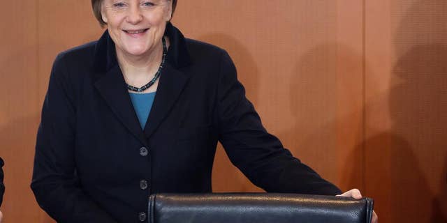 German Chancellor Angela Merkel smiles as she arrives for the weekly cabinet meeting at the chancellery in Berlin, Germany, Thursday, Dec. 11, 2014. (AP Photo/Michael Sohn)