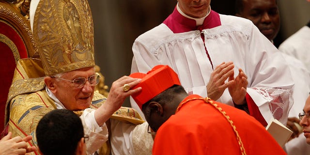 Cardinal Robert Sarah of Guinea receives the red biretta, a four-cornered red hat, from Pope Benedict XVI during the Consistory ceremony in Saint Peter's Basilica at the Vatican November 20, 2010.