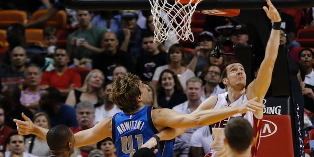 Miami Heat guard Goran Dragic (7) shoots as Dallas Mavericks forward Dirk Nowitzki (41) defends during the first half of an NBA basketball game, Friday, Jan. 1, 2016, in Miami. (AP Photo/Joe Skipper)