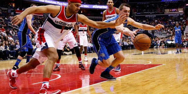 Washington Wizards forward Jared Dudley (1) and Orlando Magic guard Mario Hezonja (23), from Croatia, scramble for the rebound in the first half of an NBA basketball game, Friday, Jan. 1, 2016, in Washington. (AP Photo/Alex Brandon)