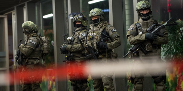 German special police stand in front of the Munich, southern Germany, main train station Thursday evening, Dec. 31, 2015 after police warned of 'imminent threat' of terror attack and ordered two train stations to be cleared. (Sven Hoppe/dpa via AP)