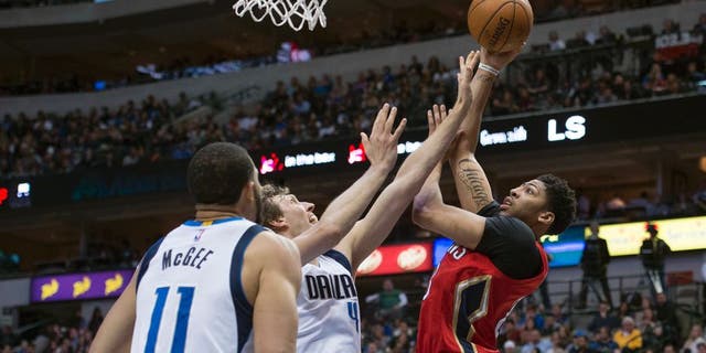 Jan 2, 2016; Dallas, TX, USA; New Orleans Pelicans forward Anthony Davis (23) shoots over Dallas Mavericks forward Dirk Nowitzki (41) and center JaVale McGee (11) during the second half at the American Airlines Center. The Pelicans defeat the Mavericks 105-98. Mandatory Credit: Jerome Miron-USA TODAY Sports