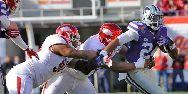 Jan 2, 2016; Memphis, TN, USA; Kansas State Wildcats running back Charles Jones (24) carries the ball against the Arkansas Razorbacks defense during the first half at Liberty Bowl. Mandatory Credit: Justin Ford-USA TODAY Sports