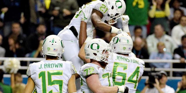 Jan 2, 2016; San Antonio, TX, USA; Oregon Ducks running back Royce Freeman (21) is hoisted by teammates after scoring on a 4-yard touchdown run against the TCU Horned Frogs during the 2016 Alamo Bowl at Alamodome. Mandatory Credit: Kirby Lee-USA TODAY Sports