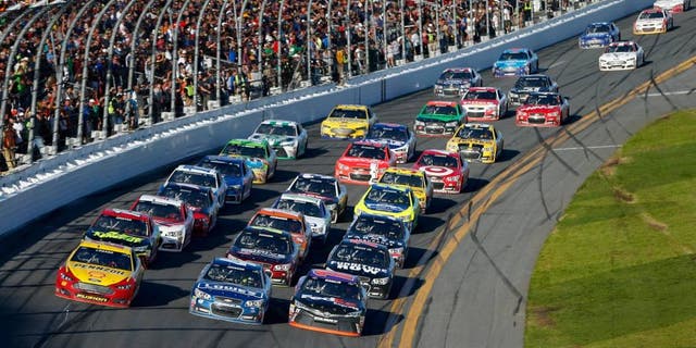 DAYTONA BEACH, FL - FEBRUARY 22: Joey Logano, driver of the #22 Shell Pennzoil Ford, Jimmie Johnson, driver of the #48 Lowe's Chevrolet, and Denny Hamlin, driver of the #11 FedEx Express Toyota, race three-wide at the front of the field during the NASCAR Sprint Cup Series 57th Annual Daytona 500 at Daytona International Speedway on February 22, 2015 in Daytona Beach, Florida. (Photo by Jonathan Ferrey/NASCAR via Getty Images)