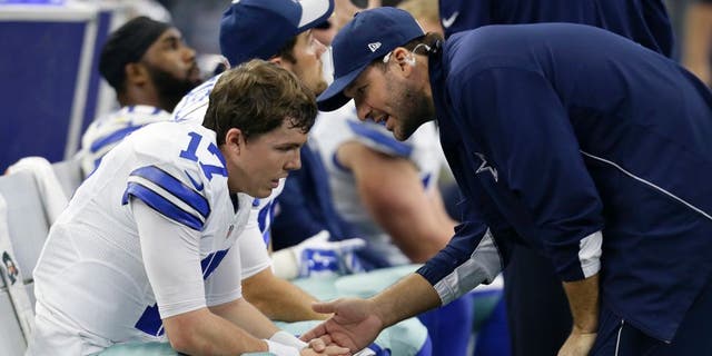 Dallas Cowboys quarterback Kellen Moore, left, talks with injured quarterback Tony Romo, right, in the second half of an NFL football game against the Washington Redskins on Sunday, Jan. 3, 2016, in Arlington, Texas. (AP Photo/Tim Sharp)