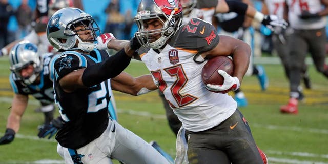 Jan 3, 2016; Charlotte, NC, USA; Tampa Bay Buccaneers running back Doug Martin (22) stiff arms Carolina Panthers cornerback Josh Norman (24) during the second quarter at Bank of America Stadium. Mandatory Credit: Jeremy Brevard-USA TODAY Sports