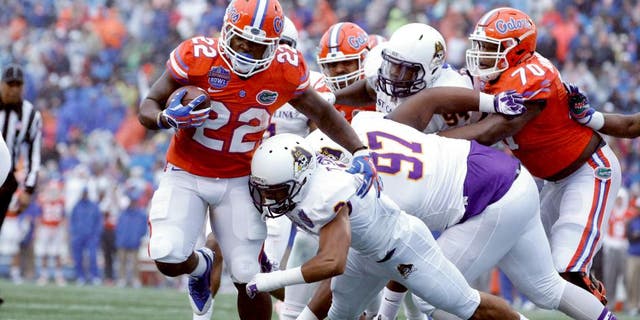 Jan 3, 2015; Birmingham, AL, USA; Florida Gators running back Adam Lane (22) is hit by East Carolina Pirates defensive back Travon Simmons (3) as he scores a touchdown during the Birmingham Bowl at Legion Field. Mandatory Credit: Marvin Gentry-USA TODAY Sports
