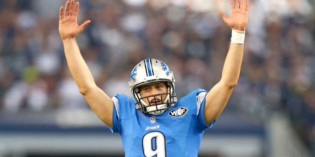 Quarterback Matthew Stafford #9 of the Detroit Lions celebrates the 18-yard rushing touchdown by running back Reggie Bush #21 in the first quarter against the Dallas Cowboys during the NFC Wildcard Playoff Game at AT&T Stadium on January 4, 2015 in Arlington, Texas. (Photo by Ronald Martinez/Getty Images)