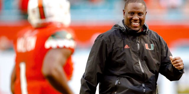 Nov 21, 2015; Miami Gardens, FL, USA; Miami Hurricanes interim head coach Larry Scott (right) greets Hurricanes running back Mark Walton (left) after Walton scored a touchdown against the Georgia Tech Yellow Jackets during the second half at Sun Life Stadium. Mandatory Credit: Steve Mitchell-USA TODAY Sports