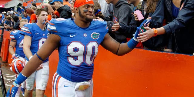 Nov 22, 2014; Gainesville, FL, USA; Florida Gators defensive lineman Jonathan Bullard (90) and quarterback Jeff Driskel (6) high five fans after they beat the Eastern Kentucky Colonels at Ben Hill Griffin Stadium. Florida Gators defeated the Eastern Kentucky Colonels 52-3. Mandatory Credit: Kim Klement-USA TODAY Sports