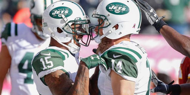 Oct 18, 2015; East Rutherford, NJ, USA; New York Jets quarterback Ryan Fitzpatrick (14) celebrates with wide receiver Brandon Marshall (15) after scoring a touchdown in the second half against the Washington Redskins at MetLife Stadium. The Jets won 34-20. Mandatory Credit: Vincent Carchietta-USA TODAY Sports