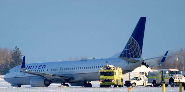 Jan. 5, 2016: Emergency vehicles surround a United Airlines aircraft as passengers wait to be evacuated at the Spokane International Airport in Spokane, Wash.