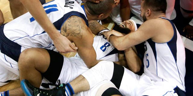 Dallas Mavericks guard Deron Williams (8) is mobbed by his teammates after scoring a 3-pointer in the final second of the second overtime in an NBA basketball game against the Sacramento Kings on Tuesday, Jan. 5, 2016, in Dallas. The Mavericks won 117-116. (AP Photo/LM Otero)