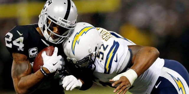 OAKLAND, CA - DECEMBER 24: Safety Charles Woodson #24 of the Oakland Raiders is tackled by linebacker Denzel Perryman #52 of the San Diego Chargers in overtime at O.co Coliseum on December 24, 2015 in Oakland, California. (Photo by Lachlan Cunningham/Getty Images)
