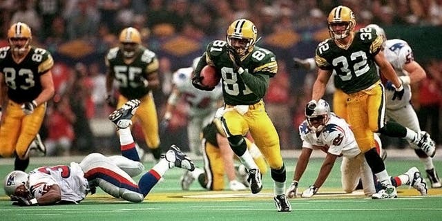 NEW ORLEANS, LA - JANUARY 26: Green Bay Packers kick returner Desmond Howard (81) leaves New England Patriots defenders behind as he runs a kickoff back 99 yards for a touchdown 26 January during third quarter action in Super Bowl XXXI at the Louisiana Superdome in New Orleans. Howard's 99-yard return is a Super Bowl record. (Photo credit should read RHONA WISE/AFP/Getty Images)