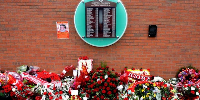 Flowers sit beneath the temporary Hillsborough memorial, ahead of a memorial service at Anfield in Liverpool, north west Engand on April 15, 2015, on the 26th anniversary of the Hillsborough Disaster, where 96 Liverpool supporters died at the 1989 FA Cup semi final between Liverpool and Nottingham Forest at Hillsborough football ground in Sheffield. AFP PHOTO / PAUL ELLIS (Photo credit should read PAUL ELLIS/AFP/Getty Images)