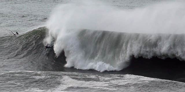 Jan. 8, 2016: A surfer wipes out under a large wave at Mavericks in Half Moon Bay, Calif.