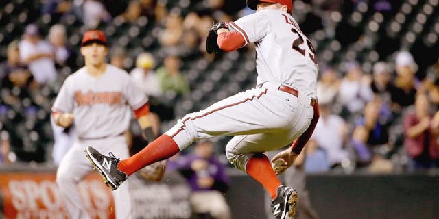 DENVER, CO - AUGUST 31: Relief pitcher Brad Ziegler #29 of the Arizona Diamondbacks makes a throwing error after fielding a ground ball by DJ LeMahieu #9 of the Colorado Rockies in the ninth inning at Coors Field on August 31, 2015 in Denver, Colorado. Ziegler would collect the loss as the Rockies defeated the Diamondbacks 5-4. (Photo by Doug Pensinger/Getty Images)