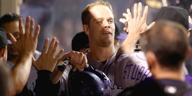 ANAHEIM, CA - MAY 12: Justin Morneau #33 of the Colorado Rockies celebrates in the dugout after scoring on Corey Dickerson's rbi double to deep right field in the fourth inning during the MLB game against the Los Angeles Angels of Anaheim at Angel Stadium of Anaheim on May 12, 2015 in Anaheim, California. The Angels defeated the Rockies 5-2. (Photo by Victor Decolongon/Getty Images)