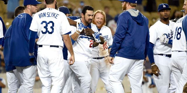 Aug 31, 2015; Los Angeles, CA, USA; Los Angeles Dodgers first baseman Adrian Gonzalez (23) celebrates with teammates after hitting a walk off during the fourteenth inning against the San Francisco Giants at Dodger Stadium. Mandatory Credit: Richard Mackson-USA TODAY Sports