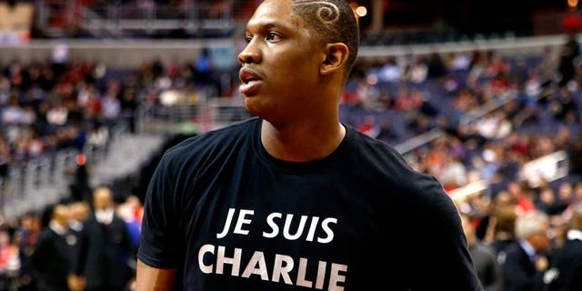 Washington Wizards center Kevin Seraphin, from France, wears a "Je Suis Charlie" T-shirt during warmups for an NBA basketball game against the Chicago Bulls, Friday, Jan. 9, 2015, in Washington. "Je Suis Charlie" ó "I Am Charlie" in English ó has become a worldwide slogan to show solidarity with Charlie Hebdo, a Paris weekly newspaper where 12 people were killed Wednesday in a terrorist attack. Seraphin was born in French Guiana and has represented France in international competitions. (AP Photo/Alex Brandon)