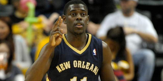 Jan 4, 2014; Indianapolis, IN, USA; New Orleans Pelicans point guard Jrue Holiday (11) signals to his teammates during the second half of the game against the Indiana Pacers at Bankers Life Fieldhouse. Indiana Pacers beat New Orleans Pelicans 99 to 82. Mandatory Credit: Marc Lebryk-USA TODAY Sports