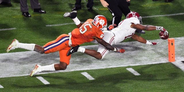 Jan 11, 2016; Glendale, AZ, USA; Alabama Crimson Tide running back Kenyan Drake (17) scores a touchdown while guarded by Clemson Tigers safety T.J. Green (15) during the fourth quarter in the 2016 CFP National Championship at University of Phoenix Stadium. Mandatory Credit: Gary A. Vasquez-USA TODAY Sports