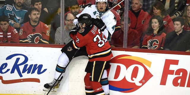 Dec 6, 2014; Calgary, Alberta, CAN; Calgary Flames center Paul Byron (32) checks San Jose Sharks defenseman Brenden Dillon (4) at Scotiabank Saddledome. Sharks won 3-2. Mandatory Credit: Candice Ward-USA TODAY Sports