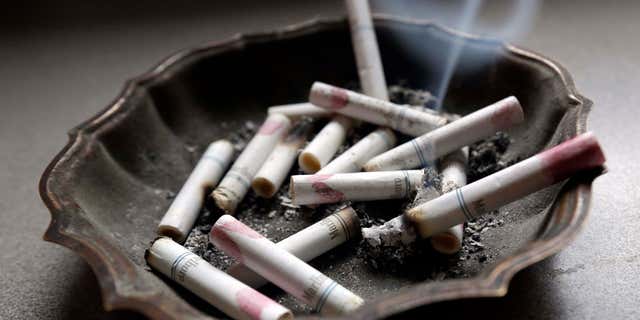 FILE - In this Saturday, March 2, 2013, photo, a cigarette burns in an ashtray at a home in Hayneville, Ala.