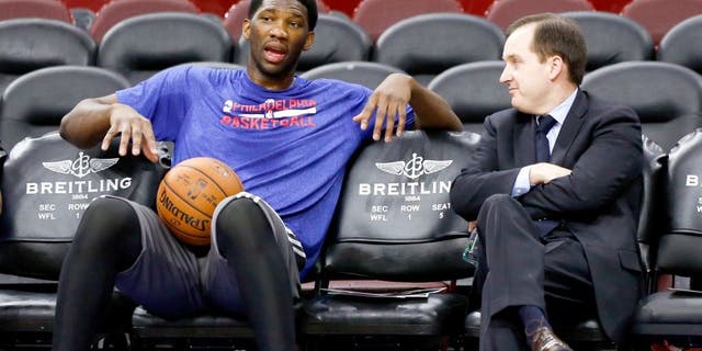 Dec 15, 2014; Philadelphia, PA, USA; Injured Philadelphia 76ers center Joel Embiid (left) talks with general manager and president Sam Hinkie (right) before a game against the Boston Celtics at Wells Fargo Center. Mandatory Credit: Bill Streicher-USA TODAY Sports