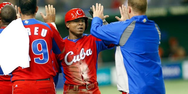 TOKYO, JAPAN - MARCH 11: Alexei Bell #88 of Team Cuba is greeted by teammates after scoring a run in the top of the fifth inning during action against Team Netherlands Pool 1, Game 5 in the second round of the 2013 World Baseball Classic at the Tokyo Dome on March 11, 2013 in Tokyo, Japan. (Photo by Yuki Taguchi/WBCI/MLB Photos via Getty Images)