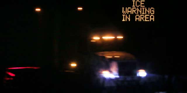 Jan. 14, 2017: Traffic moves past an icing warning sign at night on I-70 west Lawrence, Kan.