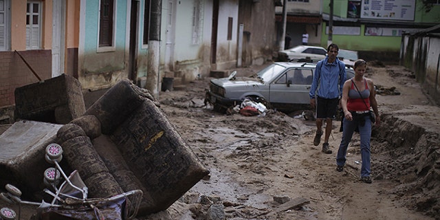 Jan. 15: People walk among debris at a street after landslides in Nova Friburgo, Brazil.