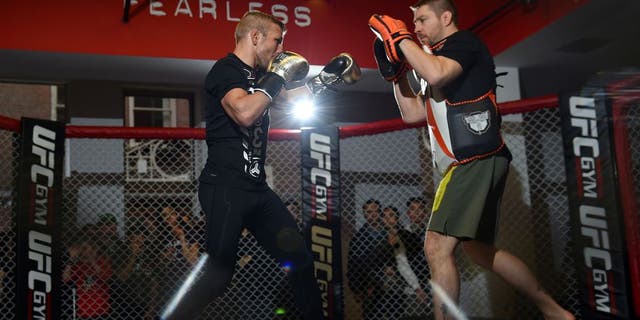 BOSTON, MA - JANUARY 15: UFC bantamweight champion TJ Dillashaw (L) works out with his coach Duane Ludwig (R) for fans and media at the UFC Gym on January 15, 2016 in Boston, Massachusetts. (Photo by Jeff Bottari/Zuffa LLC/Zuffa LLC via Getty Images)