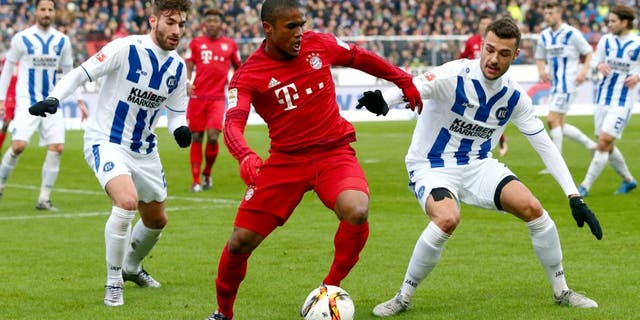 KARLSRUHE, GERMANY - JANUARY 16: Douglas Costa (C) of Muenchen is challenged by Enrico Valentini (L) and Manuel Gulde of Karlsruhe during a friendly match between Karlsruher SC and FC Bayern Muenchen at Wildpark Stadium on January 16, 2016 in Karlsruhe, Germany. (Photo by Alex Grimm/Bongarts/Getty Images)