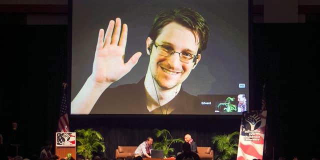 FILE - In this Feb. 14, 2015 file photo, Edward Snowden appears on a live video feed broadcast from Moscow at an event sponsored by ACLU Hawaii in Honolulu.