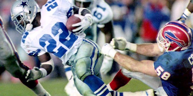Dallas Cowboys running back Emmitt Smith (L) breaks a tackle by Buffalo Bills linebacker Shane Conlan (R) 31 January, 1993 during fourth quarter action in Super Bowl XXVII in Pasadena, CA. Smith ran for 108 yards in 22 carries. The Cowboys won the game 52-17. (Photo credit should read TIM CLARY/AFP/Getty Images)