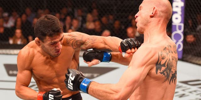 ORLANDO, FL - DECEMBER 19: (L-R) Rafael dos Anjos punches Donald Cerrone in their UFC lightweight title bout during the UFC Fight Night event at the Amway Center on December 19, 2015 in Orlando, Florida. (Photo by Josh Hedges/Zuffa LLC/Zuffa LLC via Getty Images)