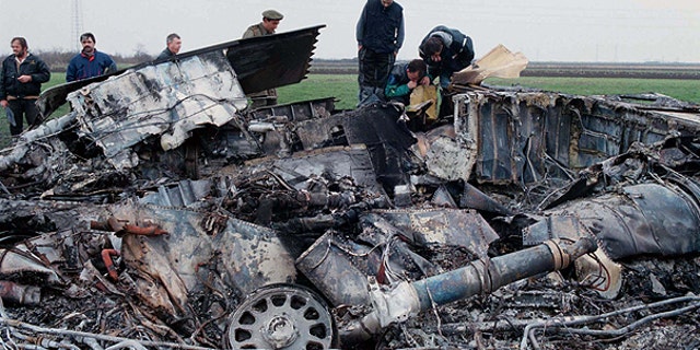 In this March 28, 1999 file photo, Yugoslav army experts check the wreckage of a downed American F-117 aircraft, in the village of Budjanovci, 30 miles northwest of Belgrade.