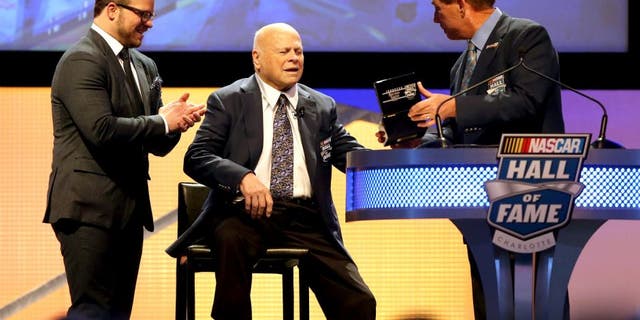 CHARLOTTE, NC - JANUARY 23: (L-R) Marcus Smith watches as his father, Bruton Smith, is inducted into the NASCAR Hall of Fame by Darrell Waltrip during the NASCAR Hall of Fame Induction Ceremony on January 23, 2016 in Charlotte, North Carolina. (Photo by Streeter Lecka/NASCAR via Getty Images)